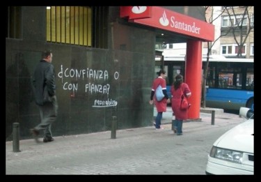 "¿Confianza o con fianza?" (Trust or finance?) a play on words on the wall of the Santander Bank, photograph by Neorrabioso.
