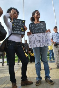 Young people hold up signs outside the National Congress, in protest against the Fiscal Reform.