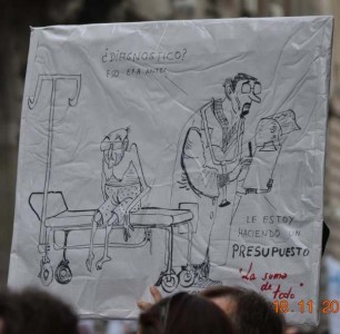 Cartel en una manifestación: «¿Diagnóstico? Eso era antes. Le estoy haciendo un presupuesto». Foto de la página de Facebook «A disfrutar de lo votado»
