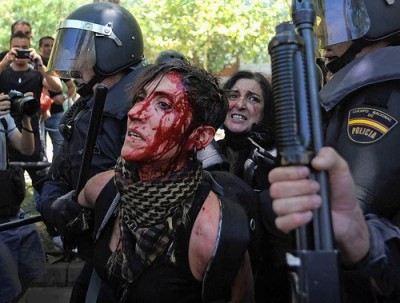 La policía antidisturbios detiene a una joven herida en una manifestación. Foto del blog «El aullido»
