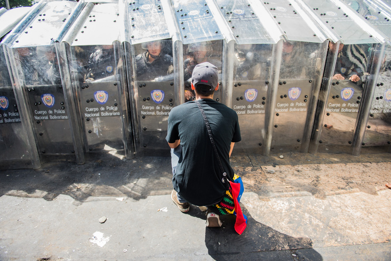 Joven tratando de persuadir a la policía en Caracas el 12 de febrero. Foto de Carlos Becerra, copyright Demotix.