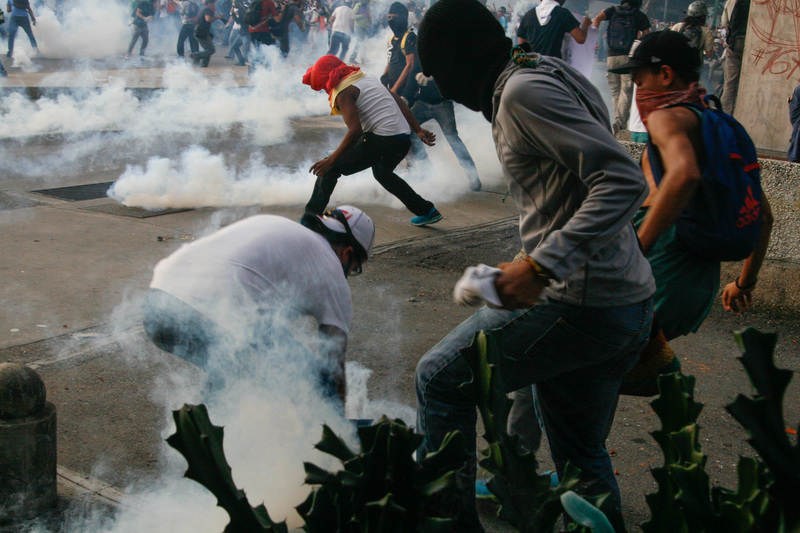 Manifestantes esquivan gases lacrimógenos lanzados por la Guardia Nacional. 19 de febrero, 2014. Altamira, Caracas. Foto de Sergio Alvarez, copyright Demotix. 
