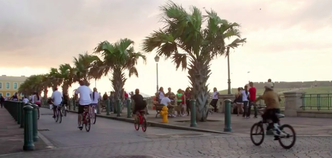 Ciclistas corriendo bicicleta en el Viejo San Juan, ciudad capital de Puerto Rico. Imagen tomada de video.