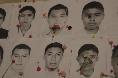 Fotos de los estudiantes mexicanos desparecidos con claveles durante Acto simbolico frente a la embajada de Mexico en Bogota, Colombia el viernes 7 de Noviembre 2014. Foto de Flickr de la Agencia Prensa Rural.